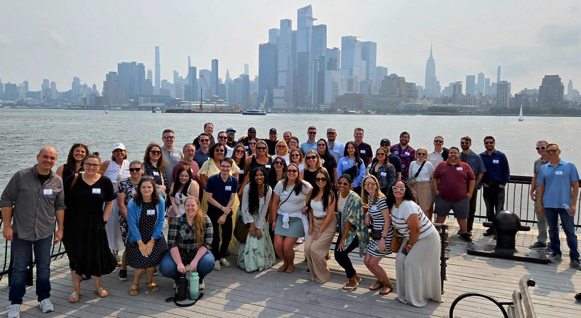 Partner Landing Page - Agency Revolution Team Standing on Pier in Front of New York on a Cloudy Day Partner Landing Page - Agency Revolution Team Standing on Pier in Front of New York on a Cloudy Day